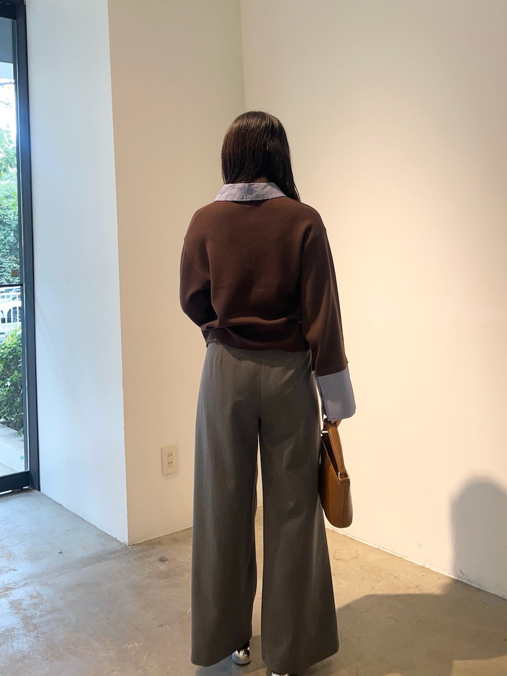 グレー系のその他パンツ、ブラウン系のニット/セーター、イエロー系のハンドバッグを着用したレディースの秋コーディネートの3枚目の写真