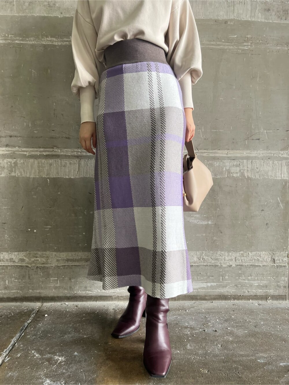 ホワイト系のニット/セーター、レッド系のブーツ、パープル系のスカートを着用したレディースの秋コーディネートの4枚目の写真