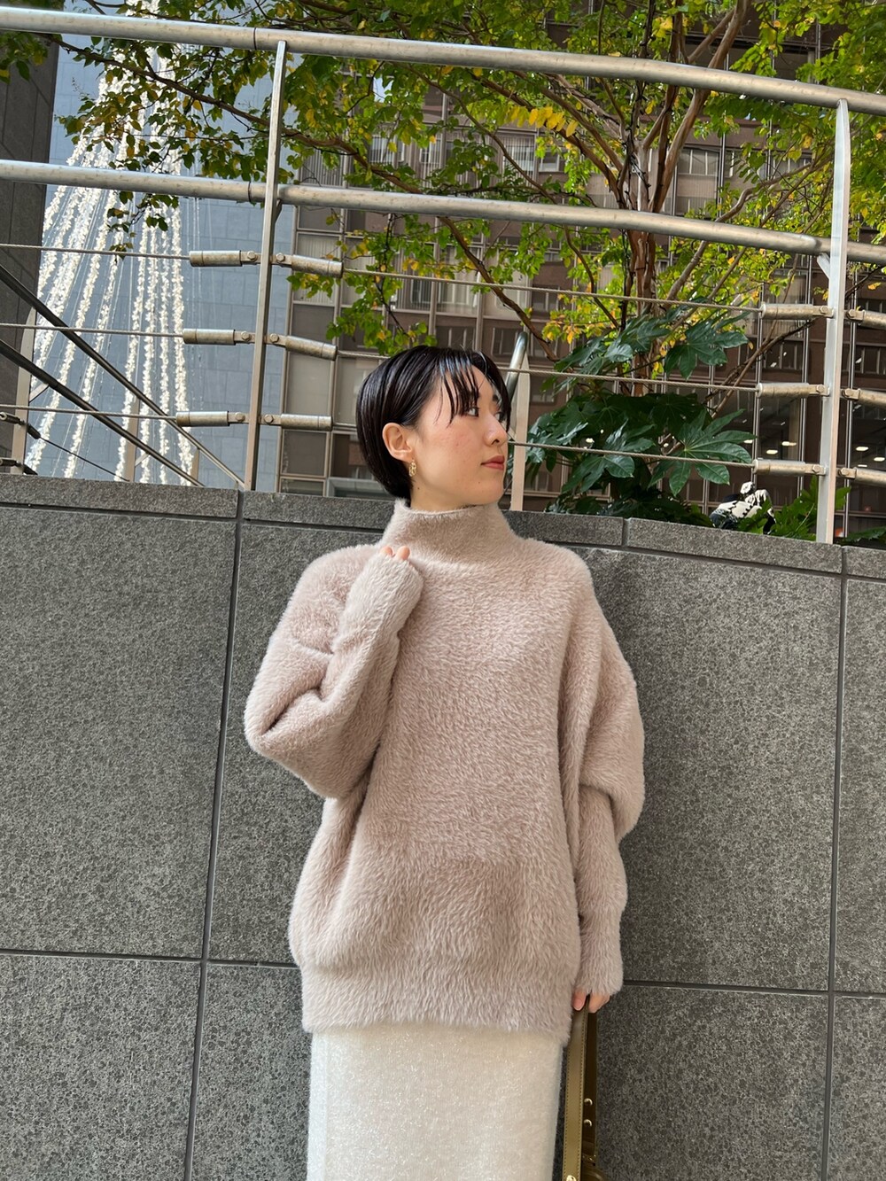 ブラウン系のショルダーバッグ、ブラウン系のニット/セーター、ベージュ系のブーツを着用したレディースの冬コーディネートの4枚目の写真