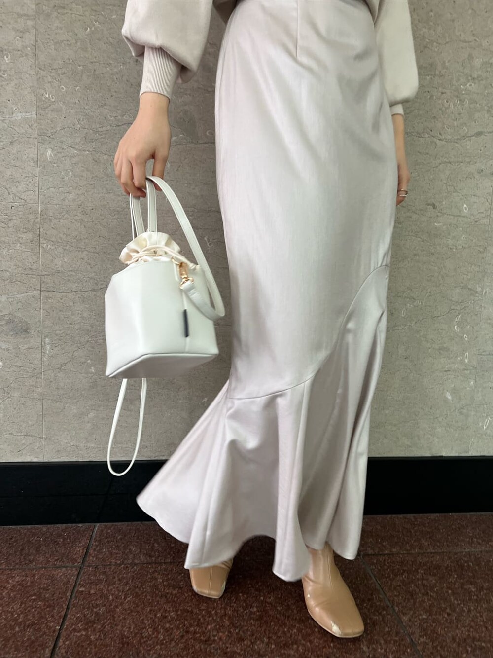 グレー系のスカート、パープル系のその他アウター、ホワイト系のハンドバッグを着用したレディースの冬コーディネートの5枚目の写真