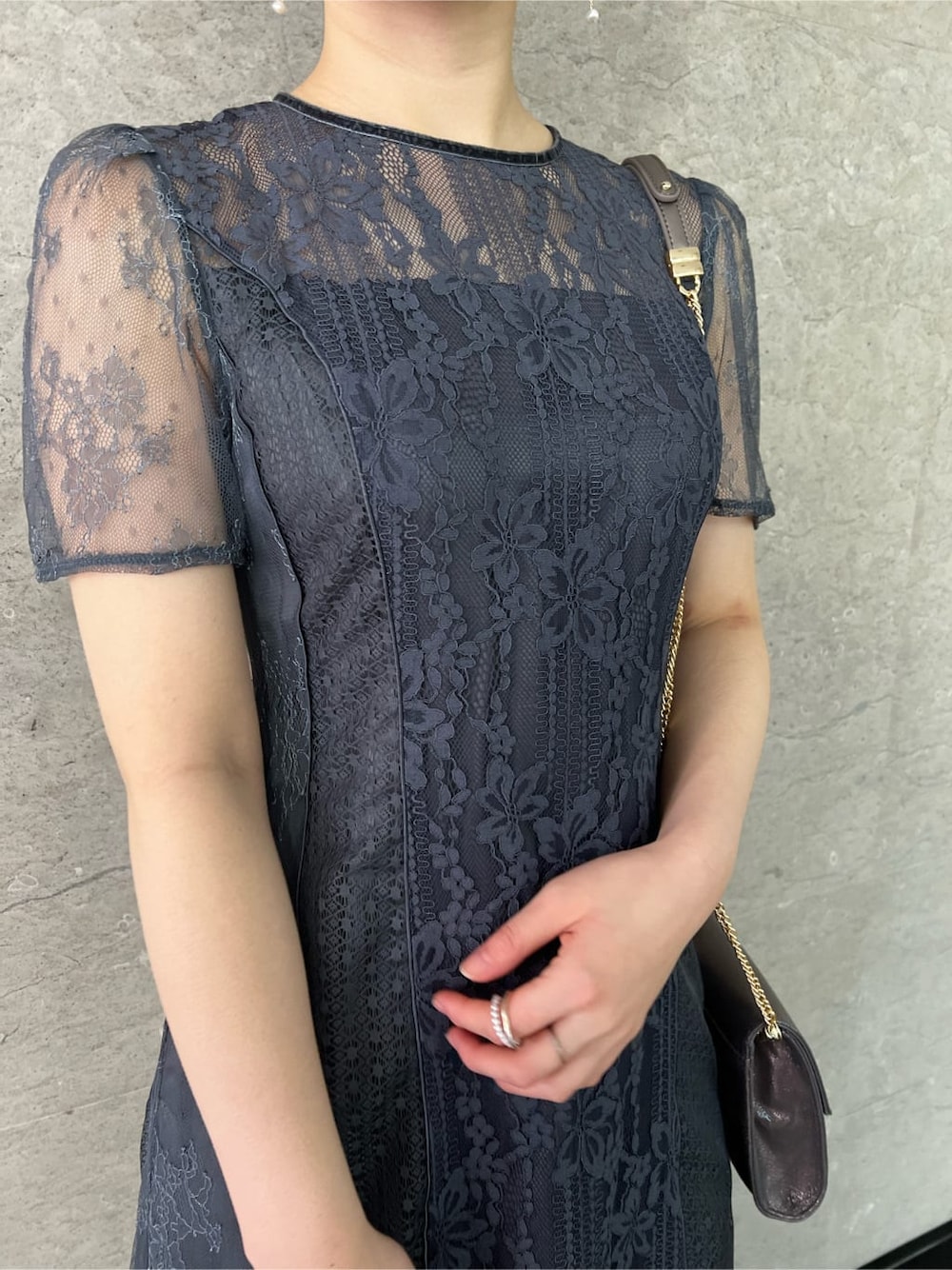シルバー系のパンプス、グレー系のドレス、シルバー系のクラッチバッグを着用したレディースの冬コーディネートの3枚目の写真