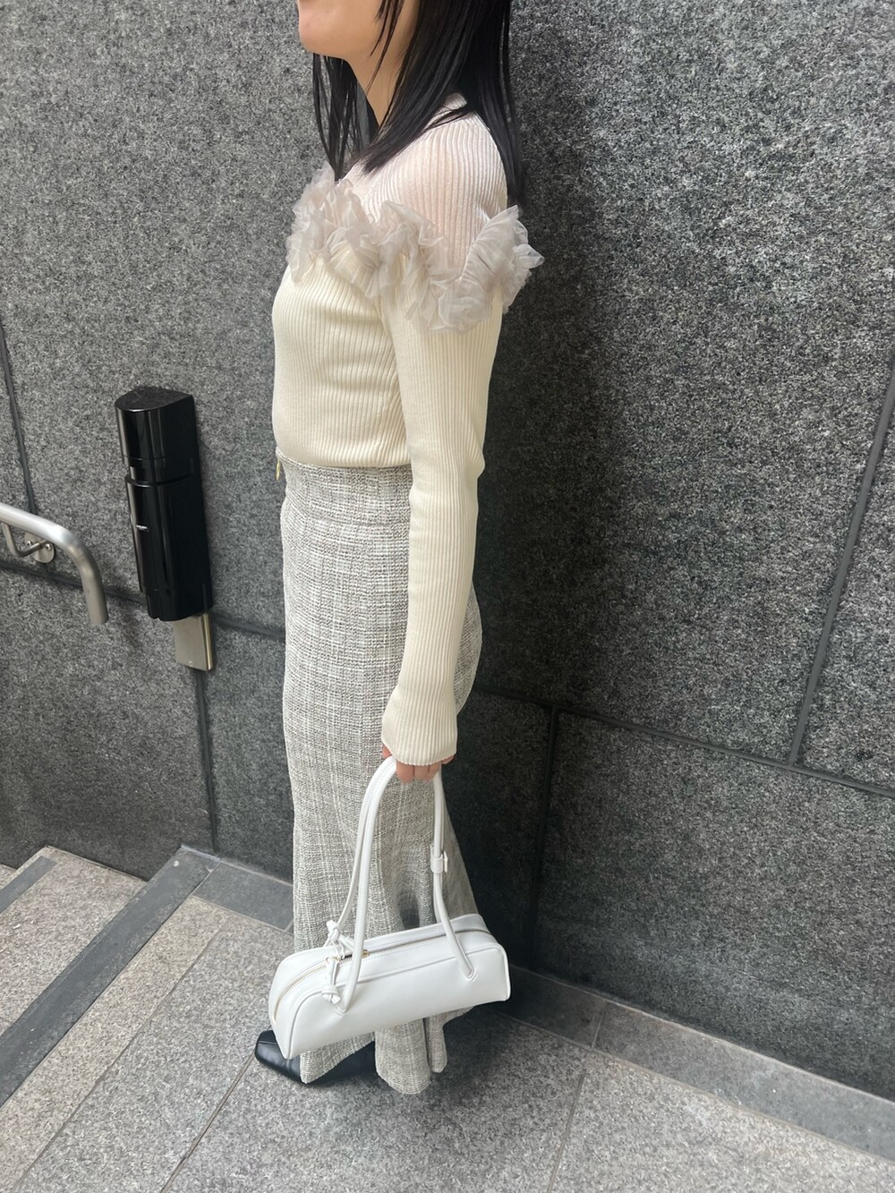 ホワイト系のニット/セーター、ホワイト系のスカート、ブラック系のブーツを着用したレディースの冬コーディネートの6枚目の写真
