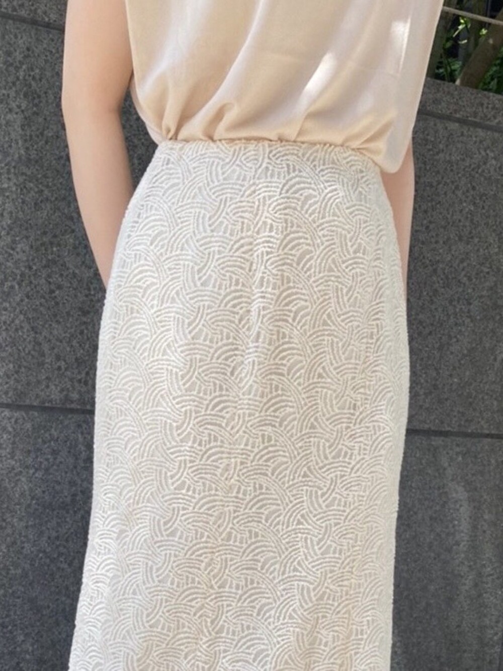 ベージュ系のニット/セーター、ホワイト系のハンドバッグ、ホワイト系のスカートを着用したレディースの夏コーディネートの5枚目の写真