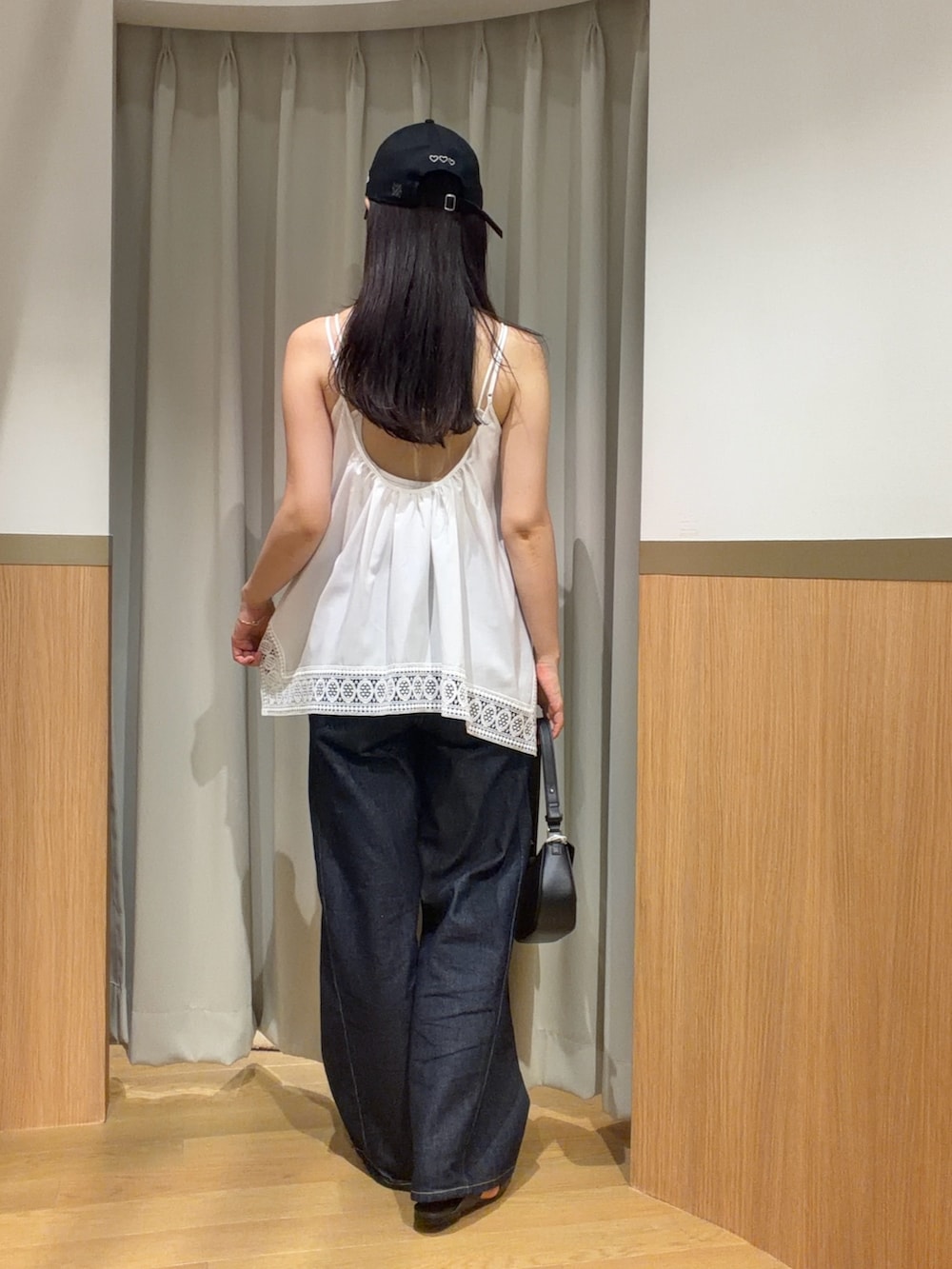 ブルー系のデニムパンツ、ホワイト系のキャミソール、ブラウン系のサンダルを着用したレディースの夏コーディネートの3枚目の写真