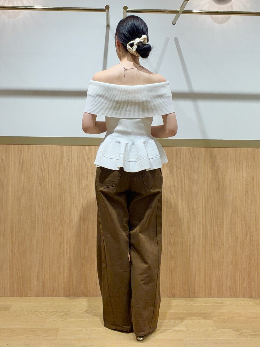 ブラウン系のデニムパンツ、ホワイト系のニット/セーター、ブラウン系のサンダルを着用したレディースの夏コーディネートの3枚目の写真