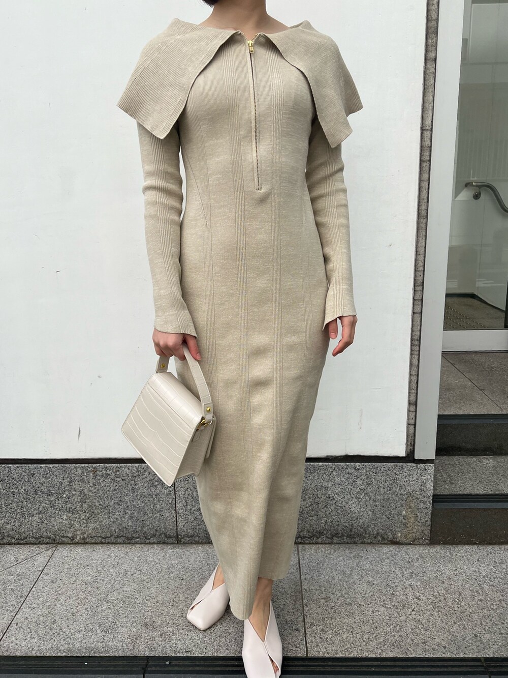 ホワイト系のパンプス、ベージュ系のワンピース、ホワイト系のショルダーバッグを着用したレディースの春コーディネートの5枚目の写真