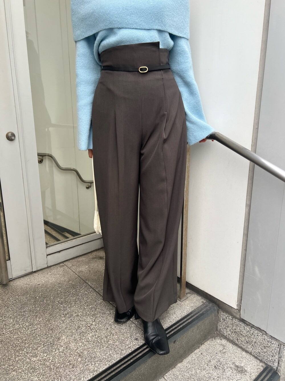 ブルー系のニット/セーター、グレー系のその他パンツ、ブラック系のブーツを着用したレディースの秋コーディネートの6枚目の写真