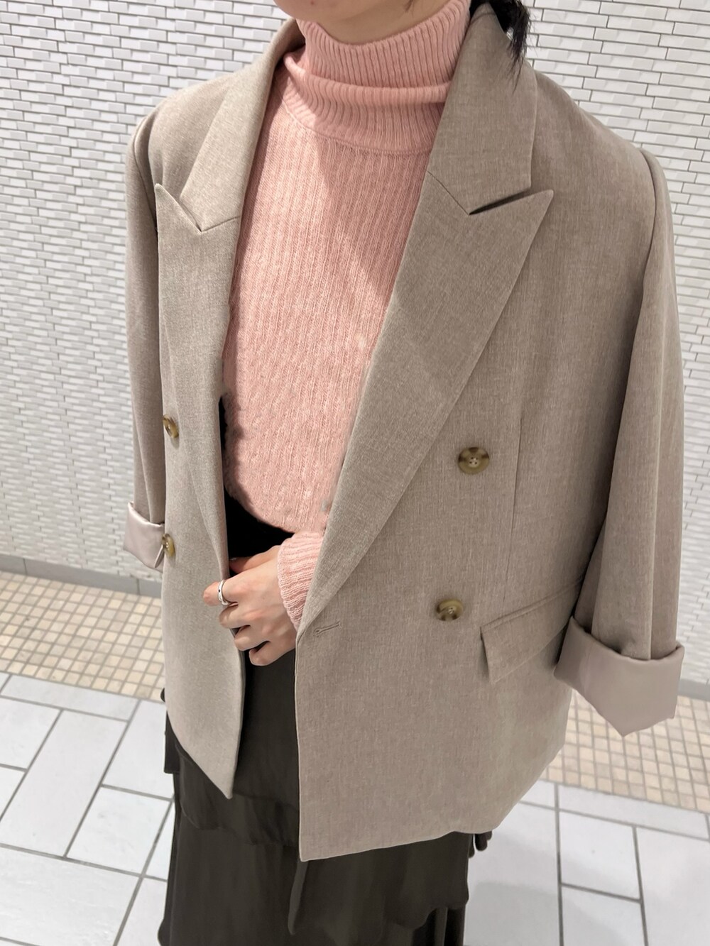 ピンク系のニット/セーター、ブラック系のブーツ、ベージュ系のテーラードジャケットを着用したレディースの秋コーディネートの4枚目の写真