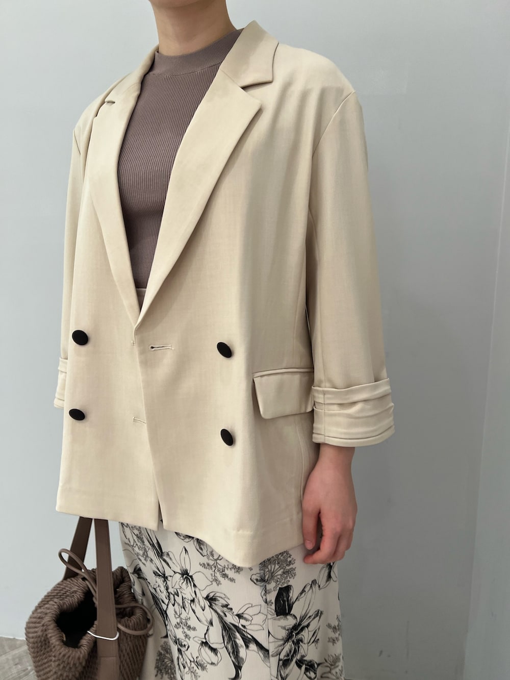 ブラウン系のサンダル、ホワイト系のスカート、ベージュ系のニット/セーターを着用したレディースの春コーディネートの2枚目の写真