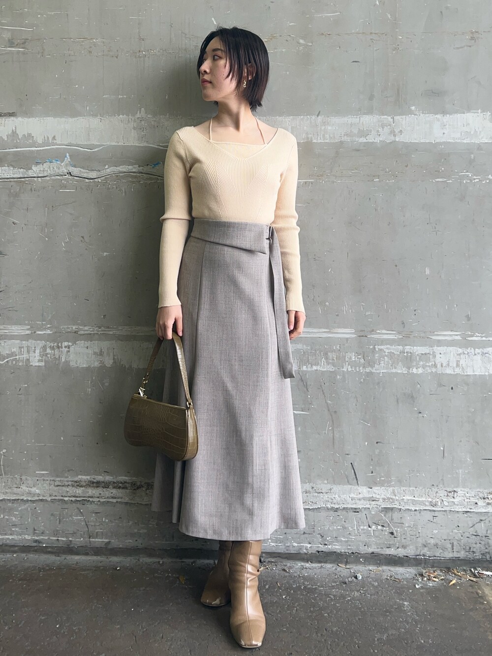 ベージュ系のブーツ、ホワイト系のニット/セーター、ホワイト系のテーラードジャケットを着用したレディースの冬コーディネートの3枚目の写真