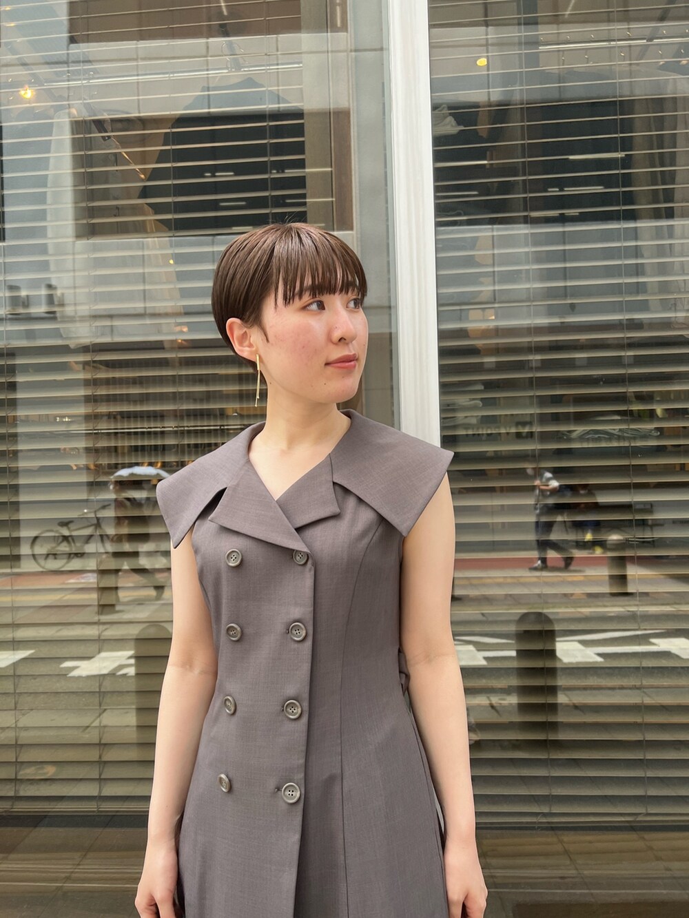 グレー系のワンピース、ブラック系のサンダル、ブラック系のハンドバッグを着用したレディースの夏コーディネートの4枚目の写真