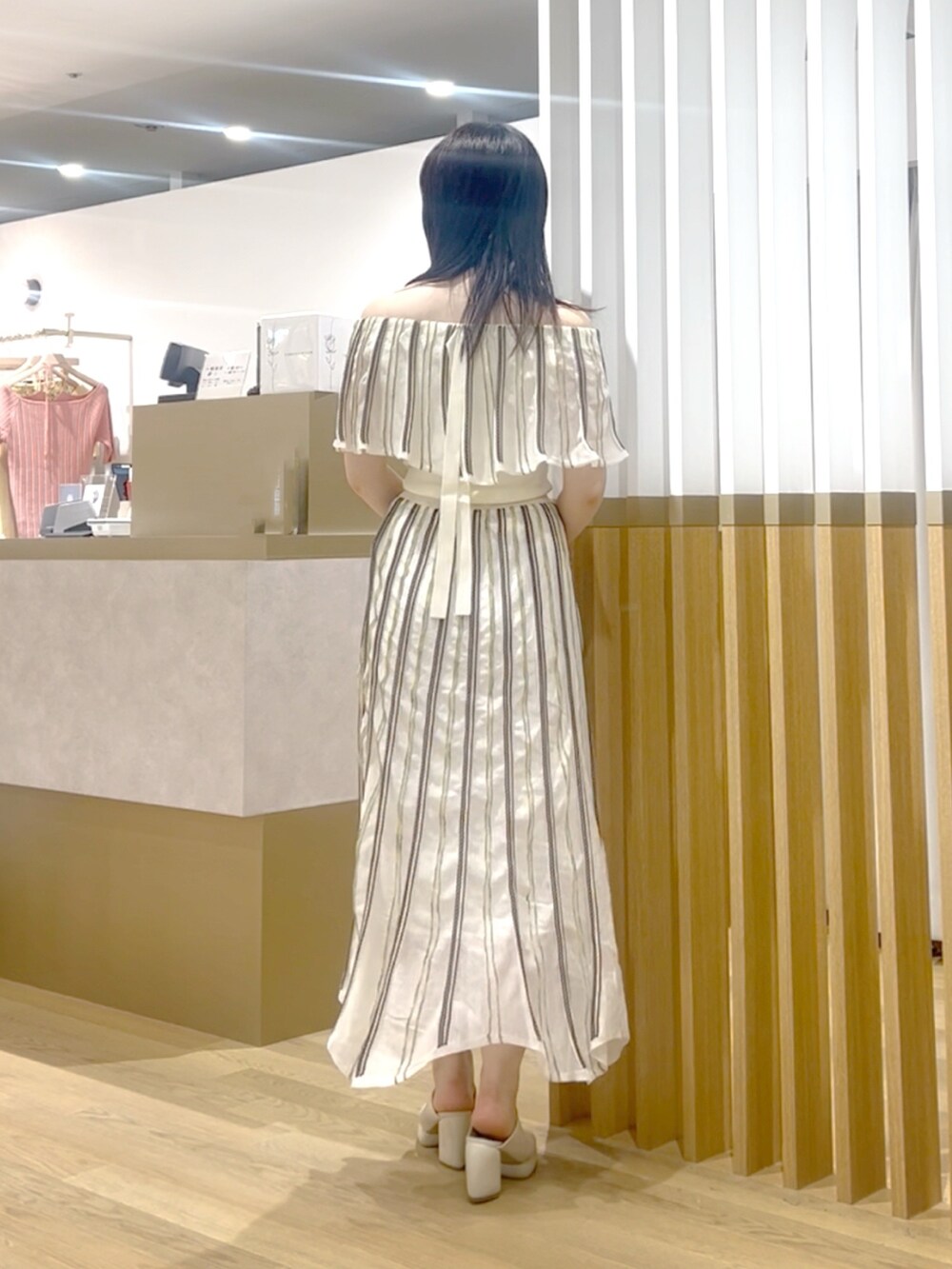 ホワイト系のニット/セーター、ホワイト系のスカート、ホワイト系のサンダルを着用したレディースの春コーディネートの2枚目の写真