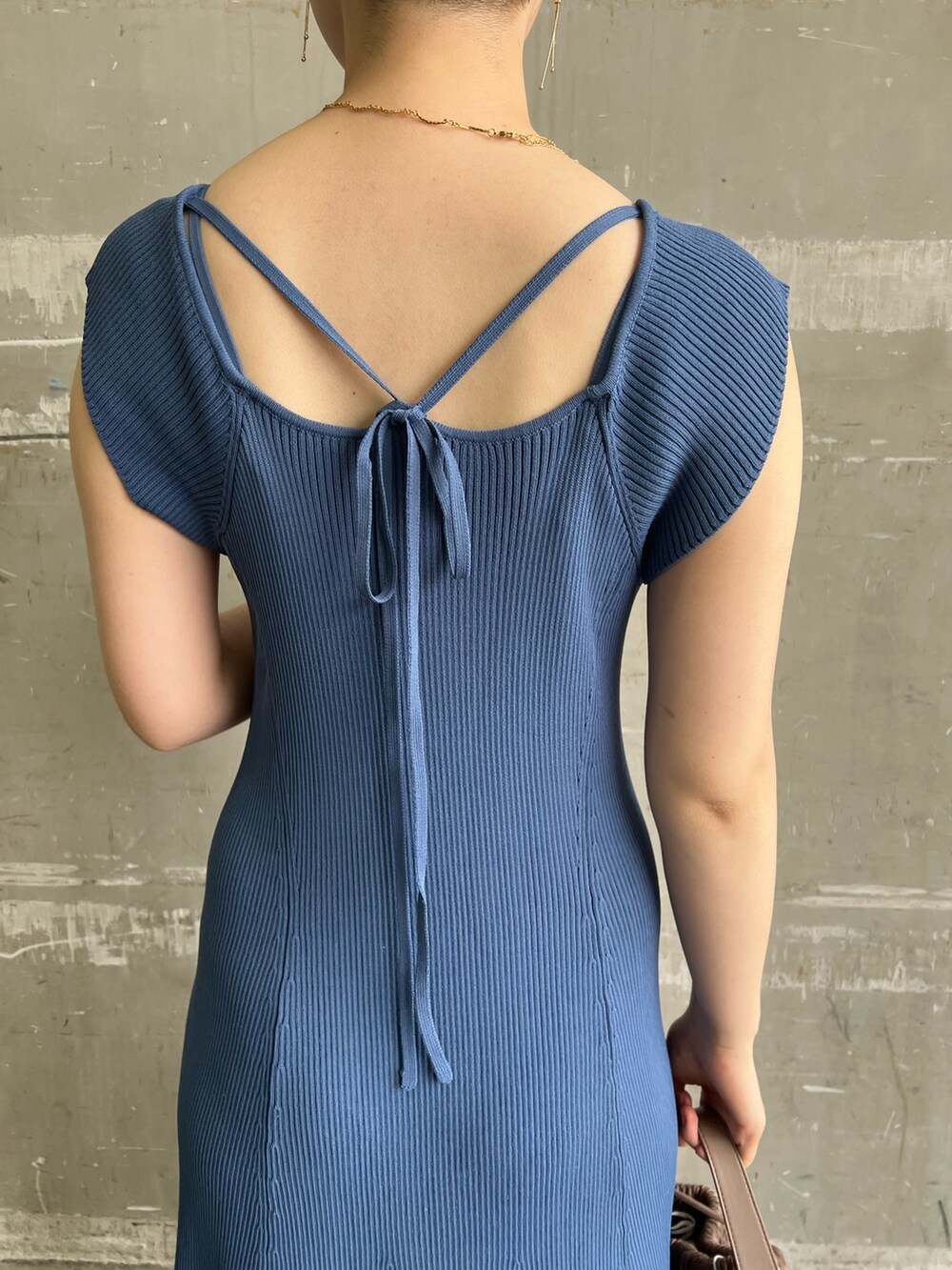 ホワイト系のハンドバッグ、ブルー系のワンピース、ベージュ系のサンダルを着用したレディースの夏コーディネートの5枚目の写真