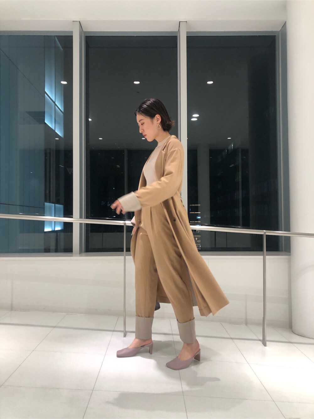 ベージュ系のその他アウター、パープル系のサンダル、パープル系のハンドバッグを着用したレディースの冬コーディネートの2枚目の写真