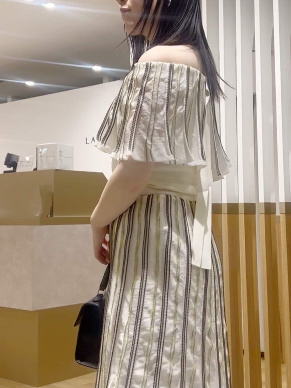 ホワイト系のニット/セーター、ホワイト系のスカート、ホワイト系のサンダルを着用したレディースの春コーディネートの5枚目の写真