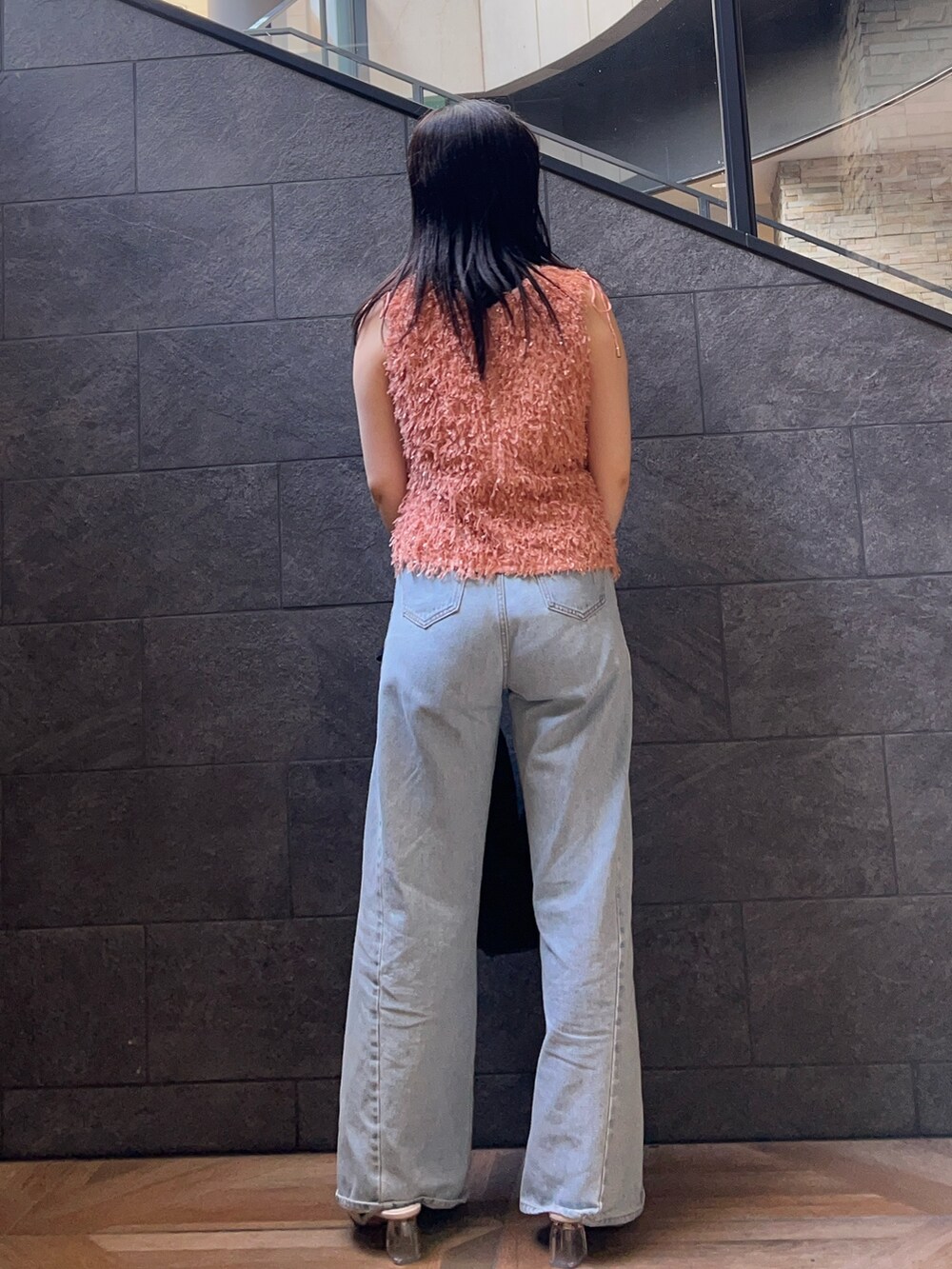 オレンジ系のTシャツ/カットソー、ホワイト系のサンダル、ブルー系のデニムパンツを着用したレディースの夏コーディネートの3枚目の写真