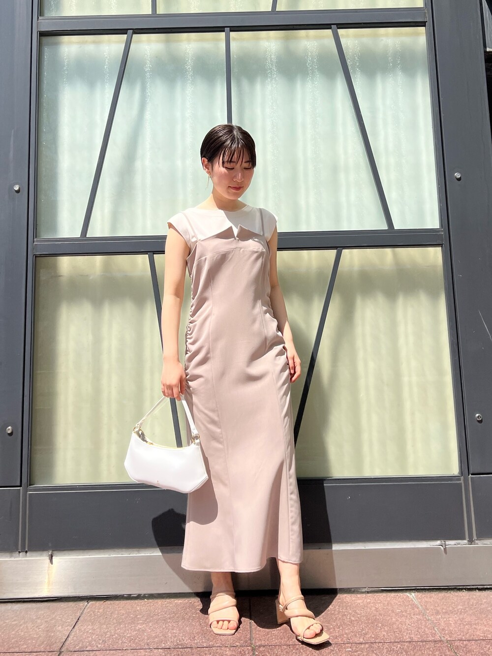 ベージュ系のワンピース、ピンク系のテーラードジャケット、ホワイト系のハンドバッグを着用したレディースの春コーディネートの4枚目の写真