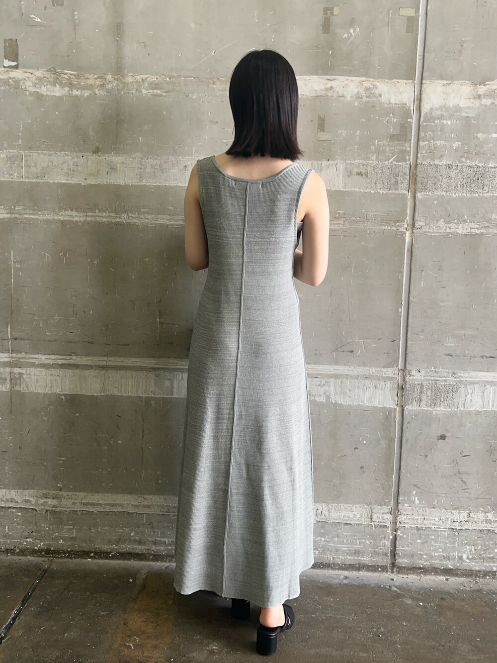 ブラック系のショルダーバッグ、ブラック系のサンダル、グリーン系のワンピースを着用したレディースの夏コーディネートの2枚目の写真