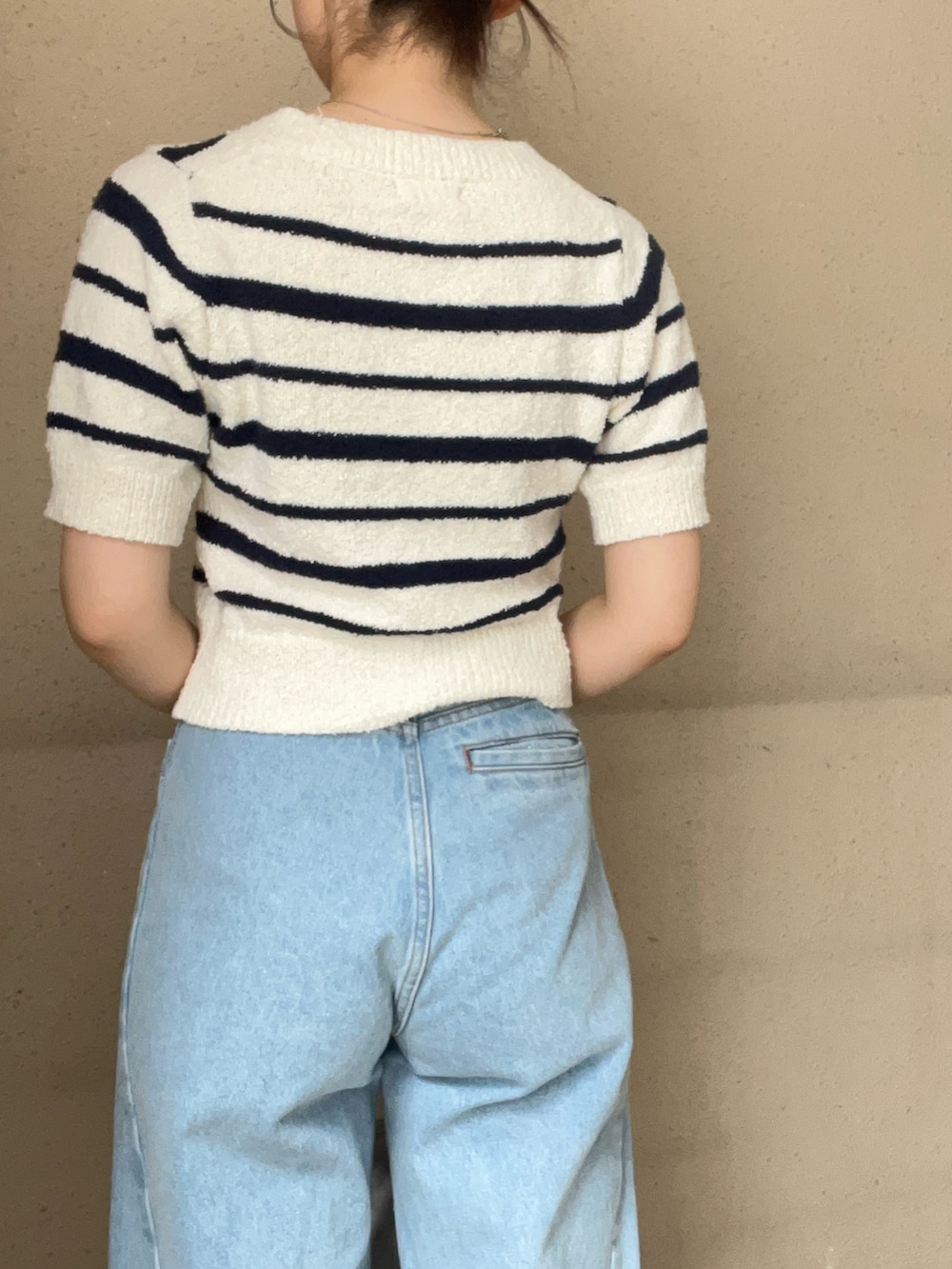 ブルー系のデニムパンツ、ホワイト系のニット/セーター、ブラック系のパンプスを着用したレディースの春コーディネートの6枚目の写真