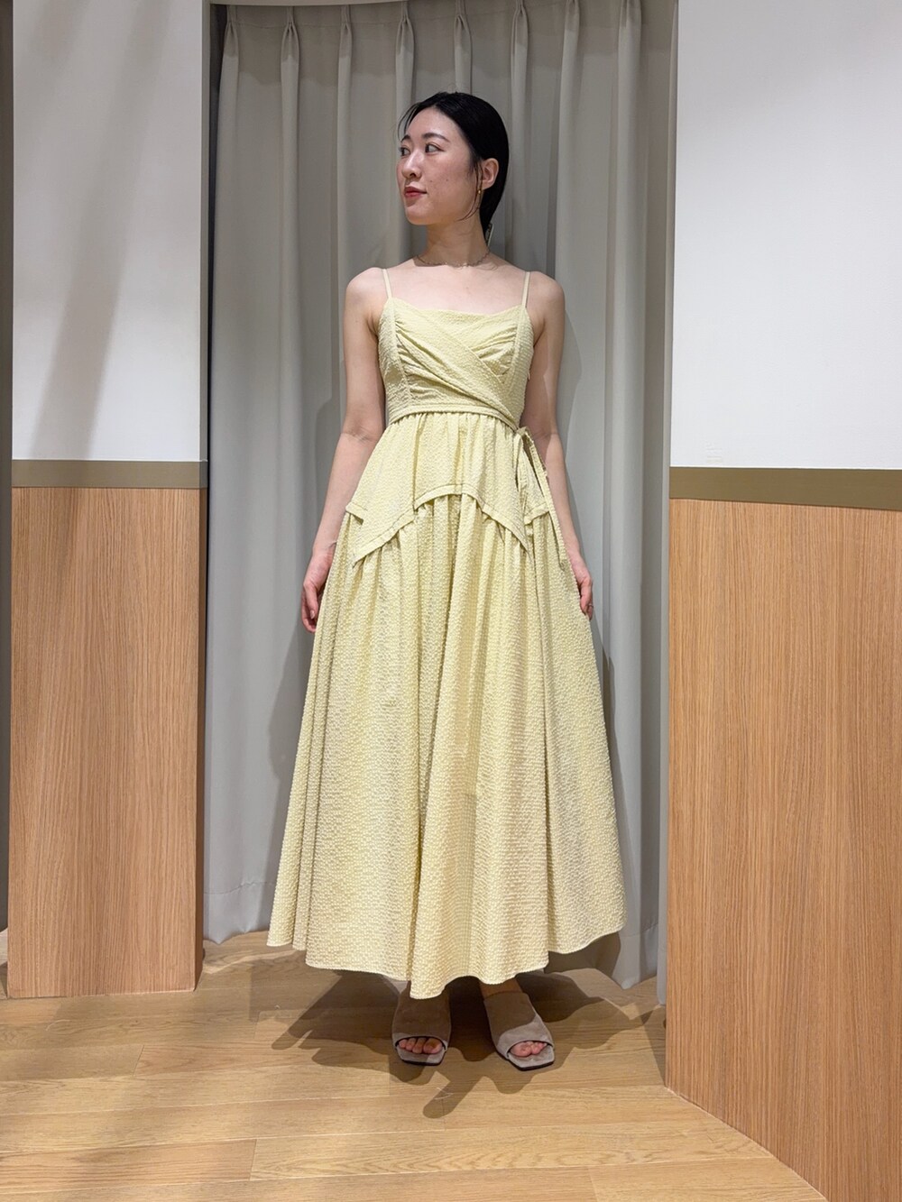 イエロー系のワンピース、ブラウン系のシャツ/ブラウス、ベージュ系のサンダルを着用したレディースの夏コーディネートの4枚目の写真