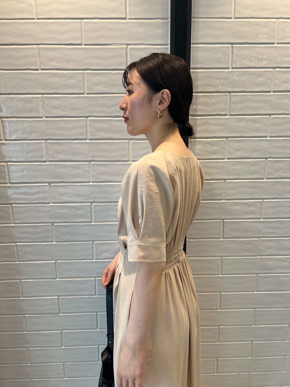 ベージュ系のワンピース、ブラック系のショルダーバッグ、その他のサンダルを着用したレディースの夏コーディネートの5枚目の写真