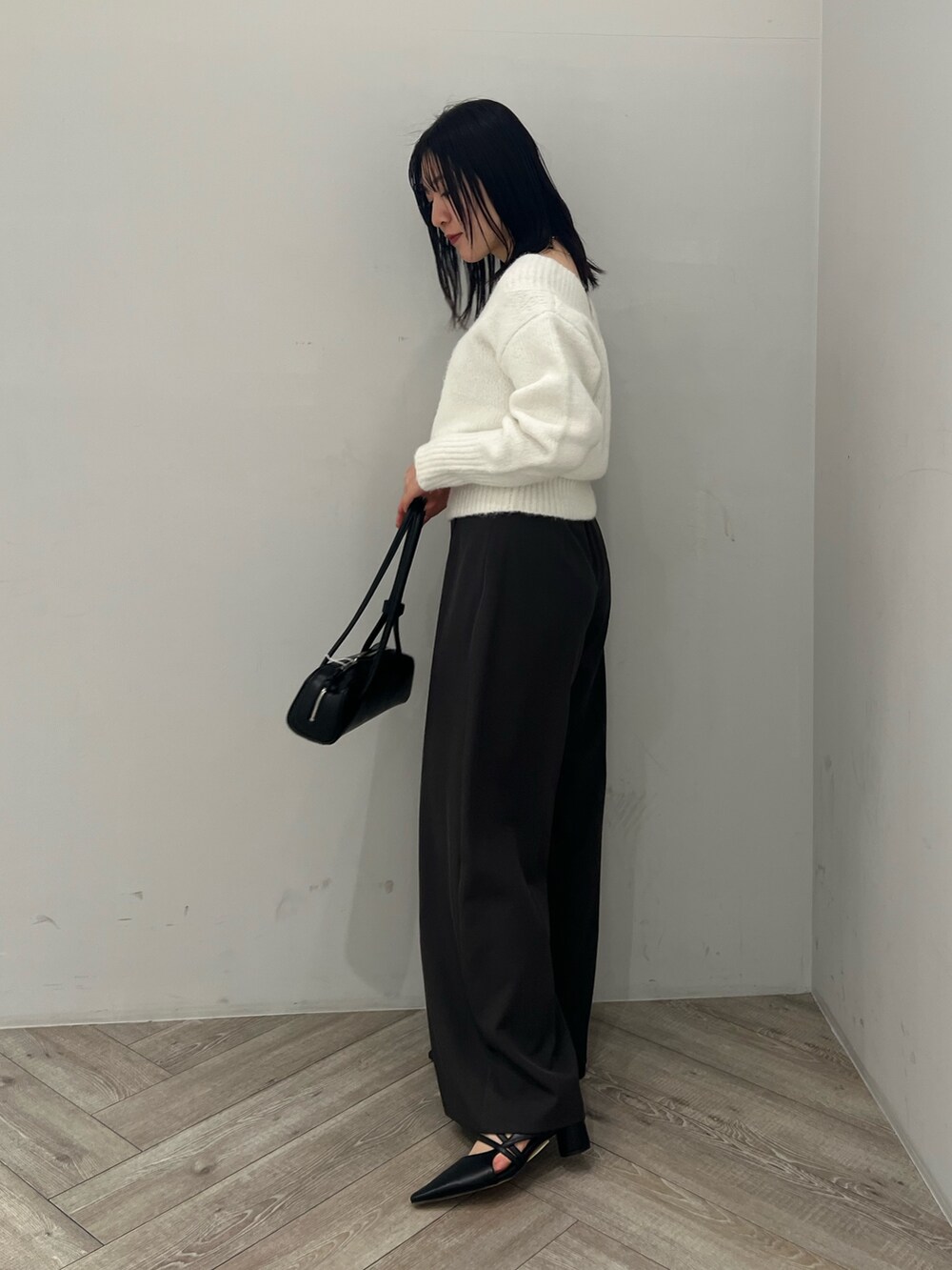 グレー系のその他パンツ、ブラック系のパンプス、ブラック系のショルダーバッグを着用したレディースの冬コーディネートの2枚目の写真