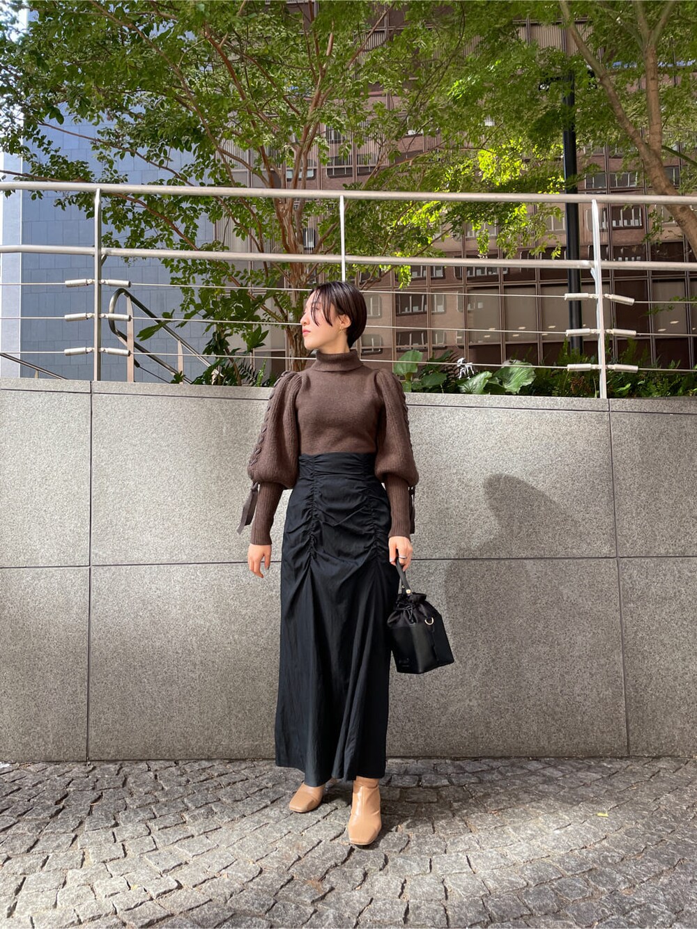 ベージュ系のその他シューズ、ホワイト系のその他アウター、ブラック系のスカートを着用したレディースの秋コーディネートの3枚目の写真