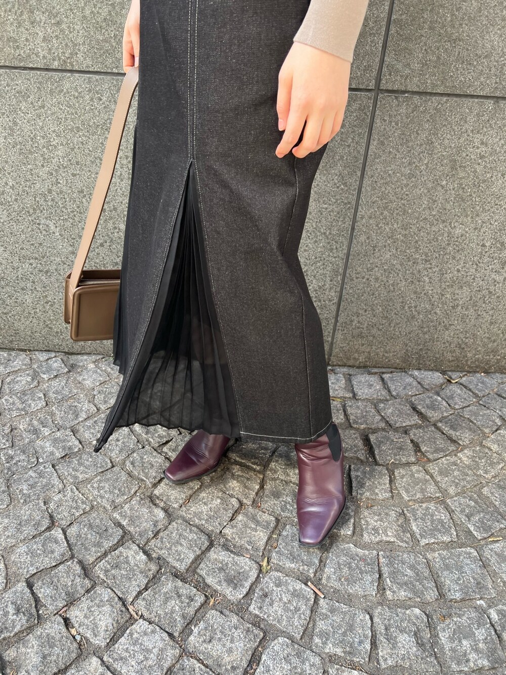 ブラック系のデニムスカート、ベージュ系のショルダーバッグ、レッド系のブーツを着用したレディースの冬コーディネートの10枚目の写真