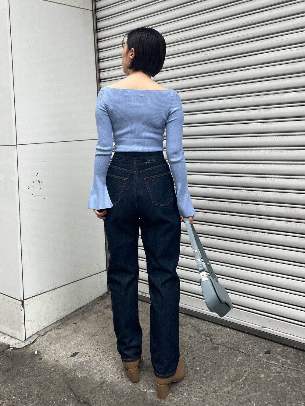 ブルー系のショルダーバッグ、ブルー系のニット/セーター、ベージュ系のブーツを着用したレディースの冬コーディネートの8枚目の写真