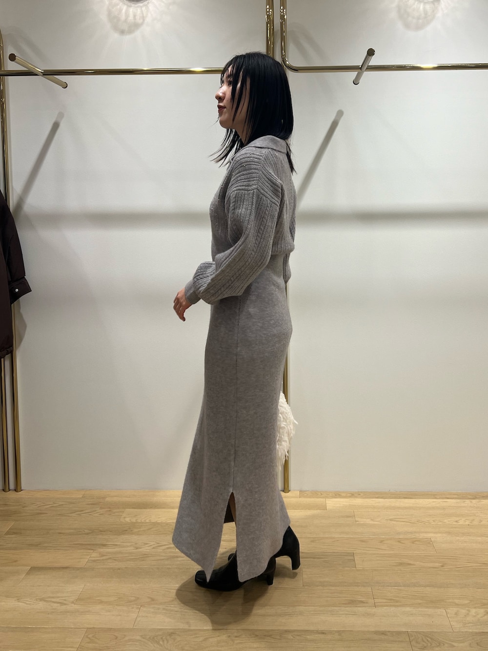 ホワイト系のハンドバッグ、グレー系のワンピースを着用したレディースの冬コーディネートの2枚目の写真