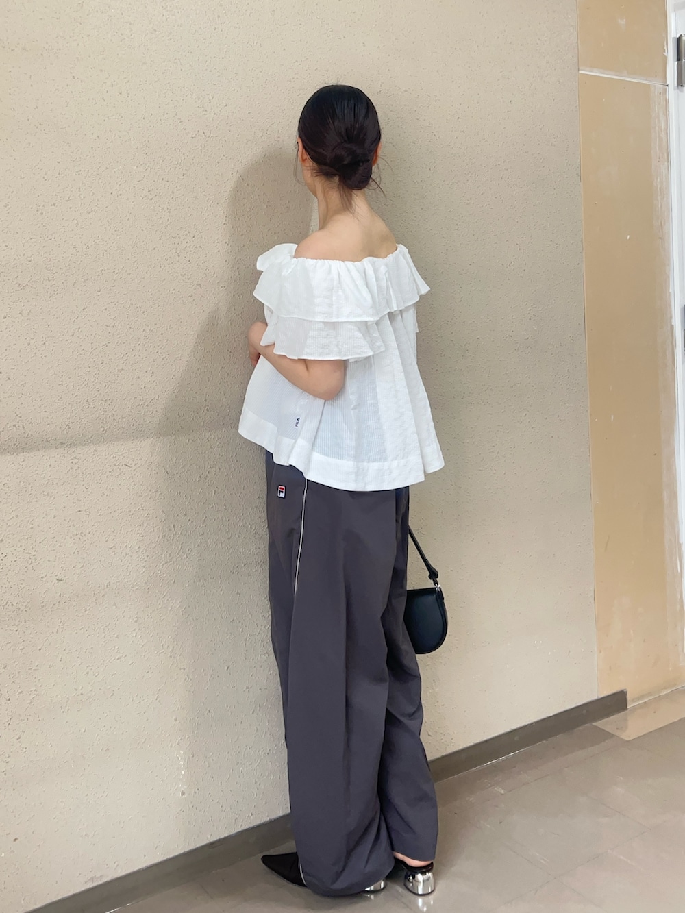 ホワイト系のシャツ/ブラウス、グレー系のその他パンツ、ブラック系のパンプスを着用したレディースの春コーディネートの2枚目の写真