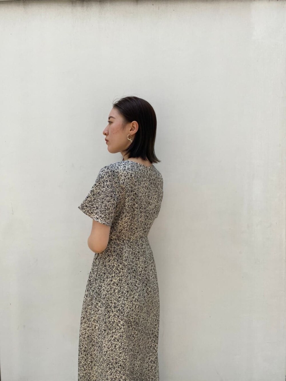 ブラウン系のパンプス、ホワイト系のハンドバッグ、ホワイト系のワンピースを着用したレディースの夏コーディネートの2枚目の写真