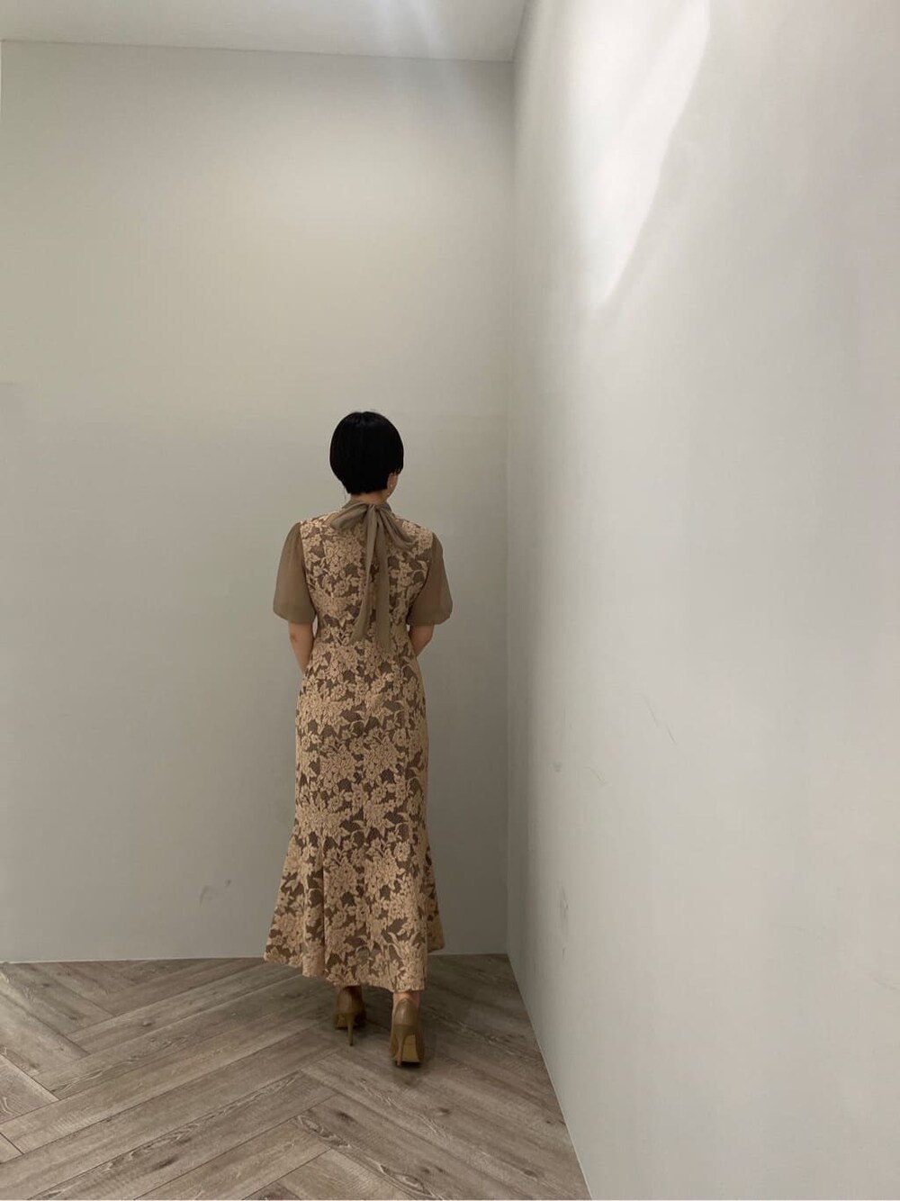 ゴールド系のクラッチバッグ、ゴールド系のパンプス、ベージュ系のドレスを着用したレディースの夏コーディネートの7枚目の写真