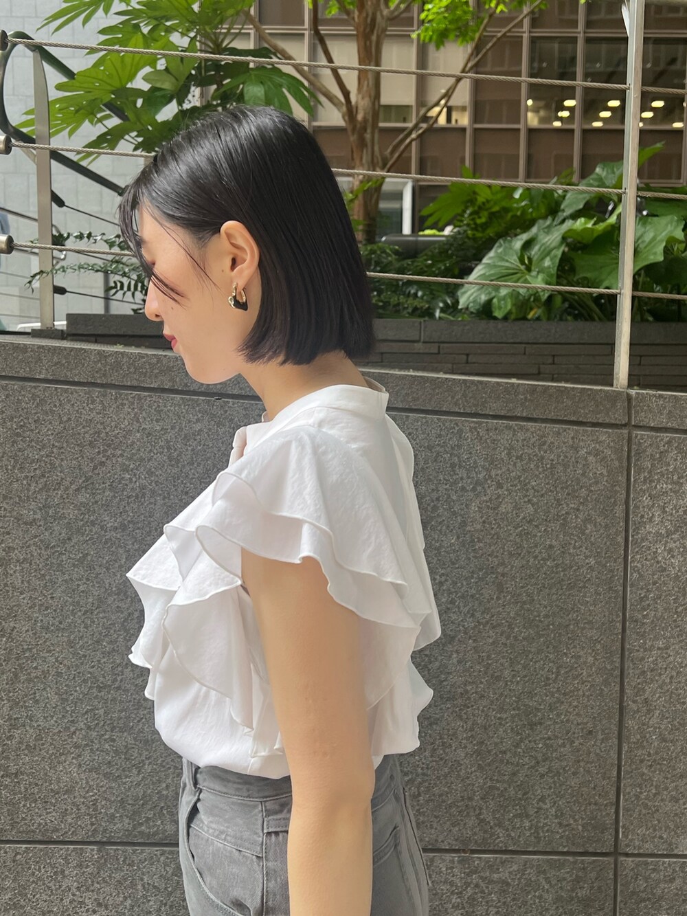 シルバー系のパンプス、グレー系のデニムパンツ、ホワイト系のシャツ/ブラウスを着用したレディースの春コーディネートの4枚目の写真