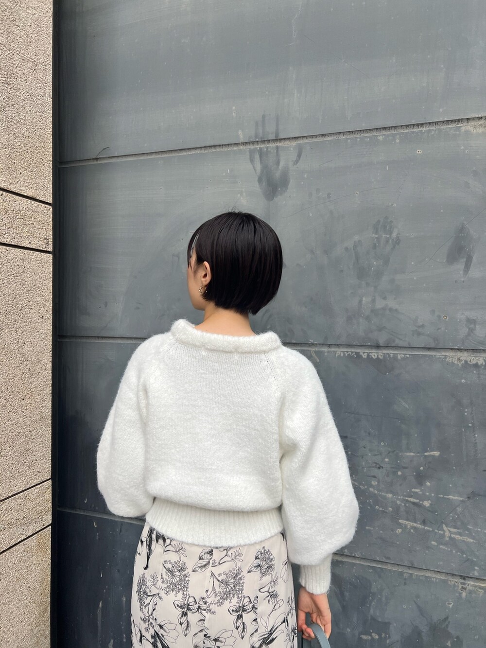 ベージュ系のブーツ、ブルー系のショルダーバッグ、ホワイト系のスカートを着用したレディースの冬コーディネートの4枚目の写真