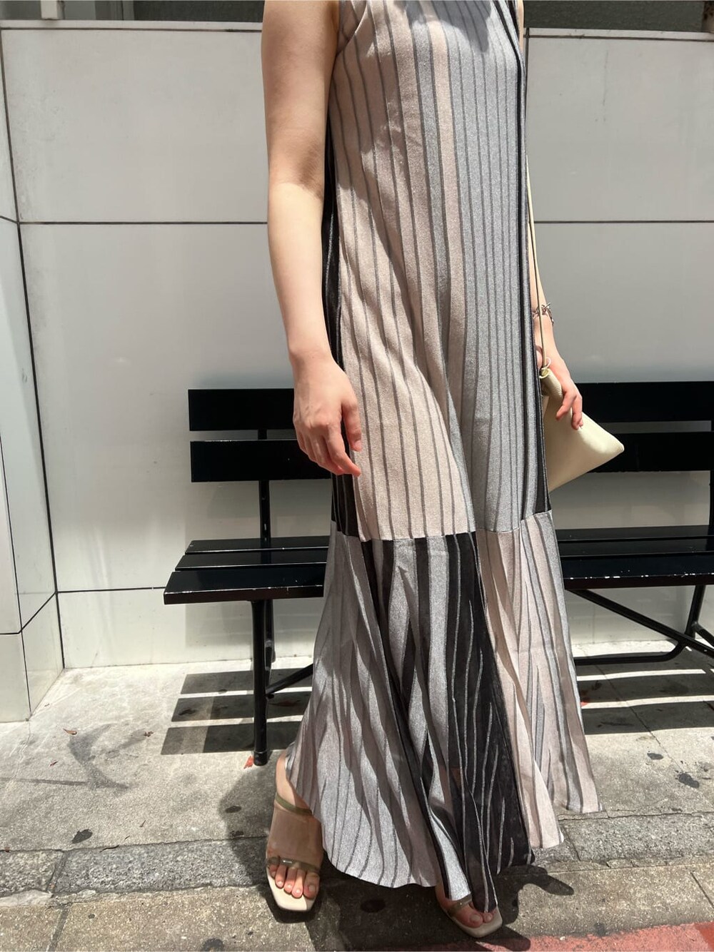 ホワイト系のハンドバッグ、グリーン系のサンダル、ブラック系のワンピースを着用したレディースの夏コーディネートの6枚目の写真