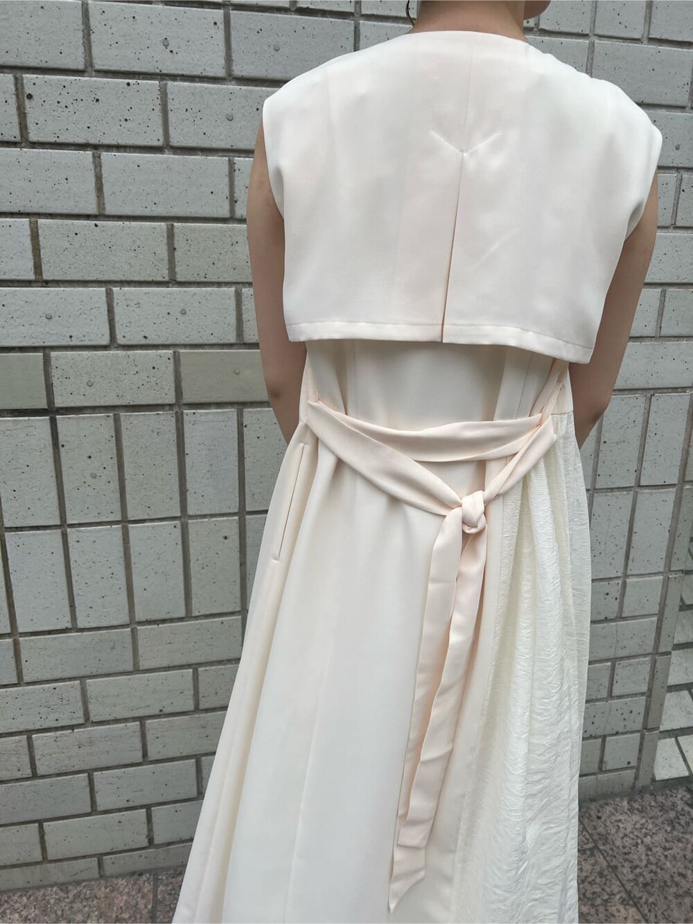 ホワイト系のハンドバッグ、ホワイト系のワンピース、グリーン系のサンダルを着用したレディースの春コーディネートの6枚目の写真