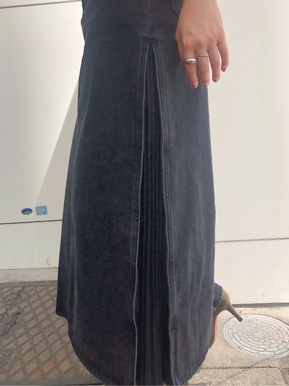 ベージュ系のブーツ、ホワイト系のショルダーバッグ、ブラック系のデニムスカートを着用したレディースの秋コーディネートの7枚目の写真