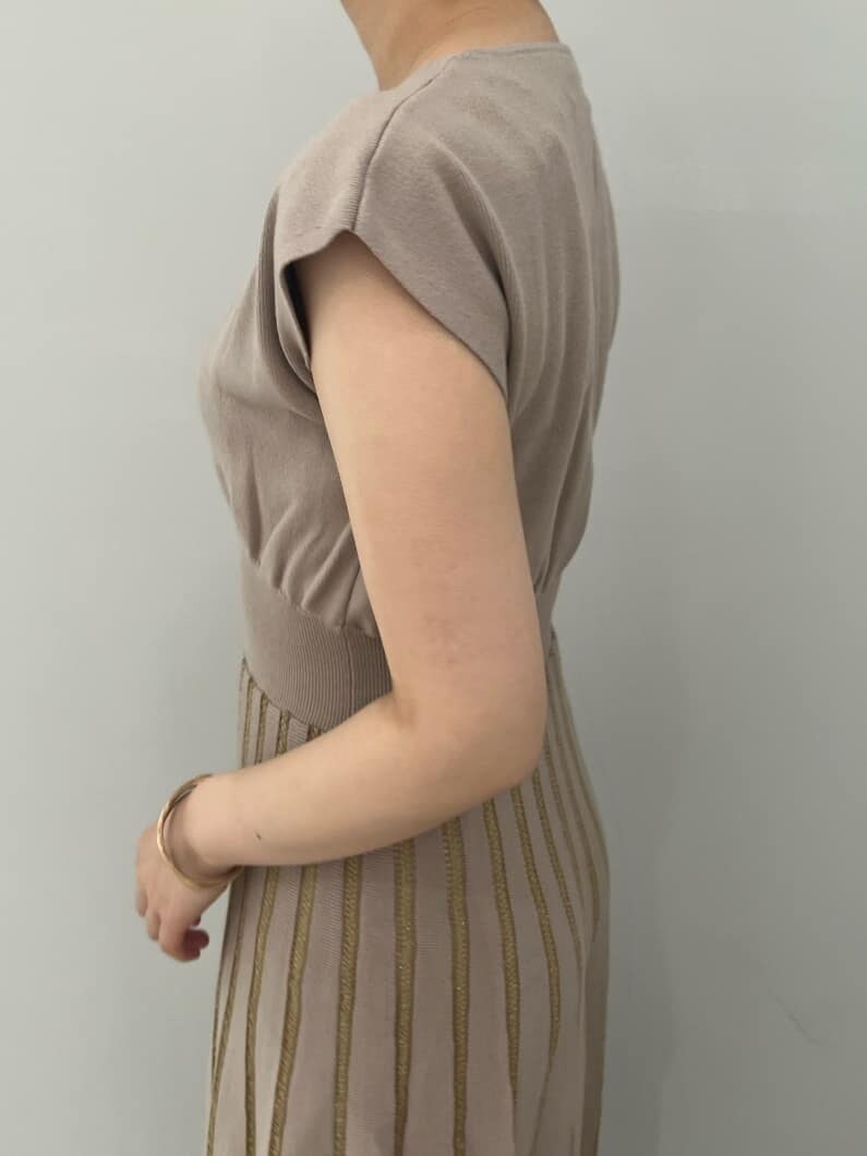 ホワイト系のハンドバッグ、ブラウン系のパンプス、ベージュ系のワンピースを着用したレディースの夏コーディネートの5枚目の写真