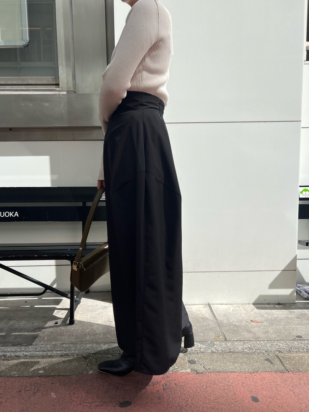 ホワイト系のニット/セーター、ブラック系のブーツ、ブラック系のスカートを着用したレディースの秋コーディネートの8枚目の写真