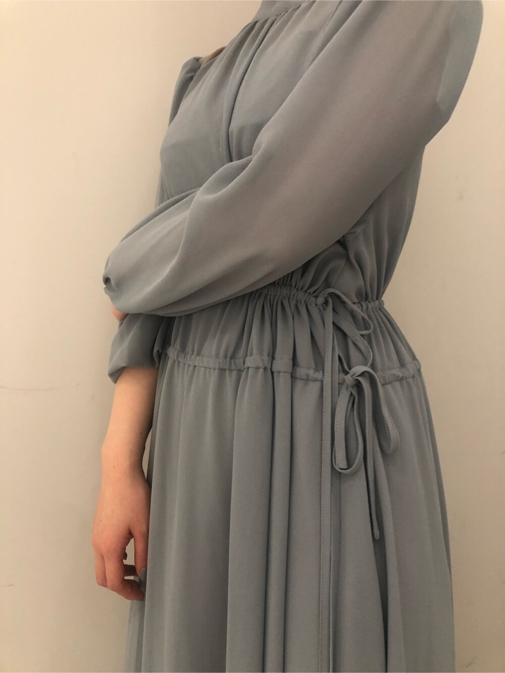 ベージュ系のハンドバッグ、ブルー系のワンピースを着用したレディースの冬コーディネートの4枚目の写真