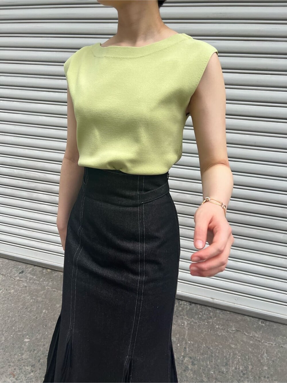 ブルー系のスカート、ベージュ系のサンダル、イエロー系のニット/セーターを着用したレディースの春コーディネートの4枚目の写真