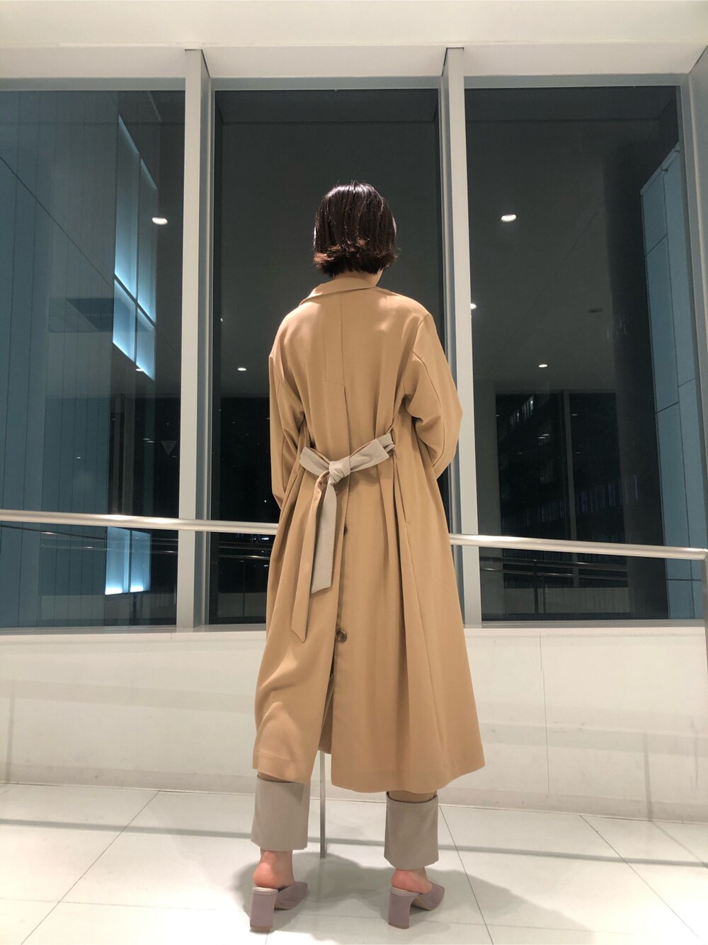 ベージュ系のその他アウター、パープル系のサンダル、パープル系のハンドバッグを着用したレディースの冬コーディネートの3枚目の写真