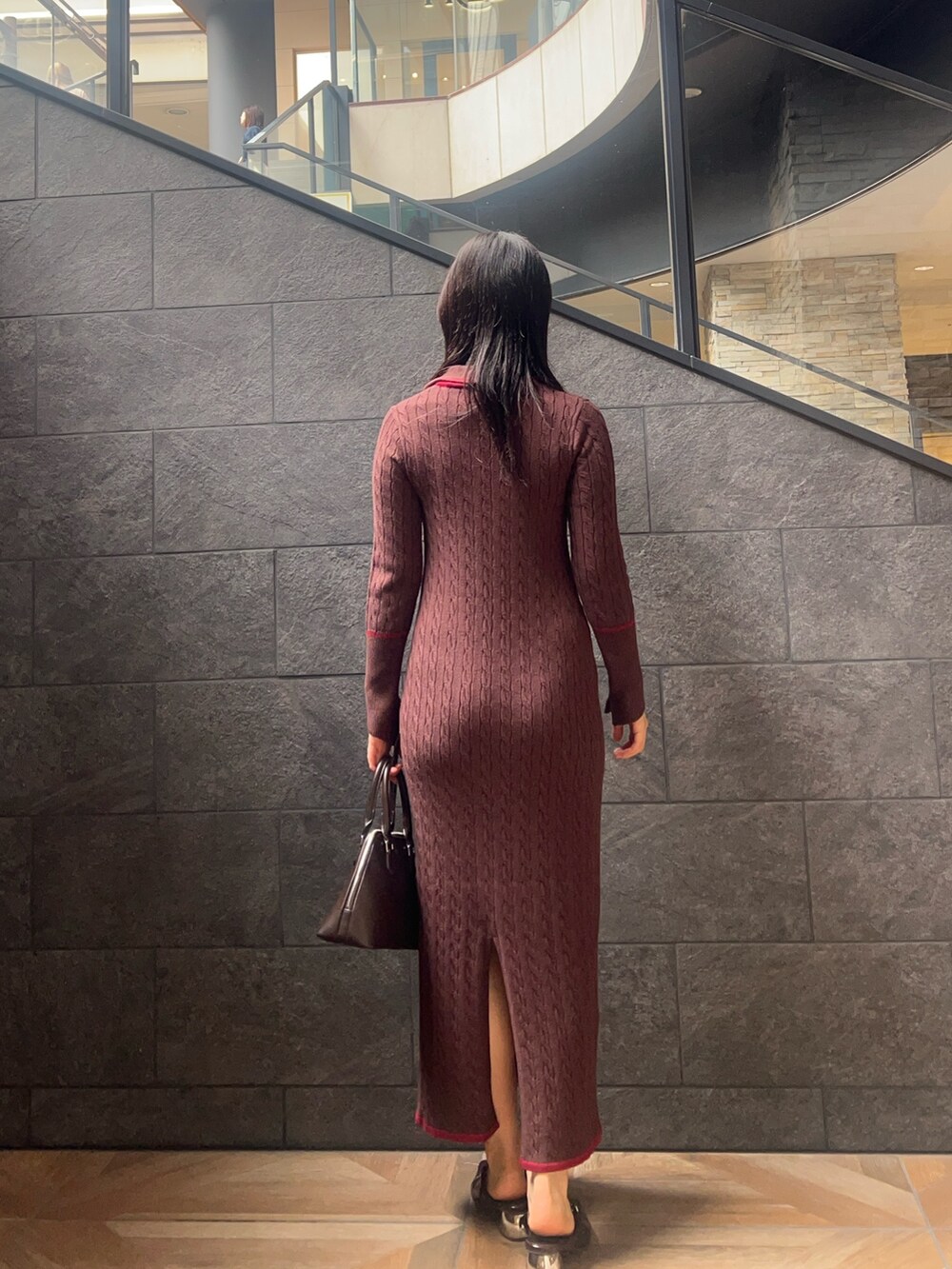 ブラウン系のワンピース、ブラウン系のボストンバッグ、ブラウン系のパンプスを着用したレディースの秋コーディネートの3枚目の写真