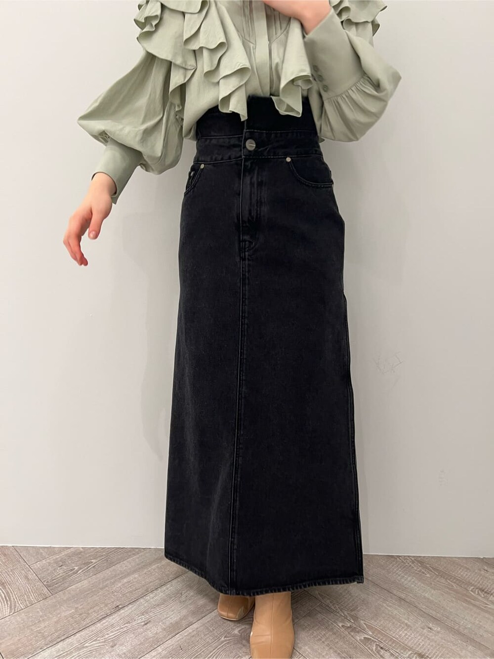 ベージュ系のその他シューズ、ブラック系のデニムスカート、グリーン系のシャツ/ブラウスを着用したレディースの冬コーディネートの5枚目の写真