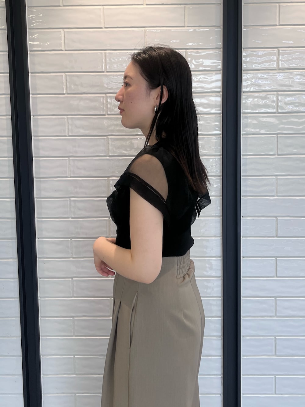 ブラウン系のその他パンツ、ブラック系のニット/セーター、ブラック系のサンダルを着用したレディースの春コーディネートの5枚目の写真