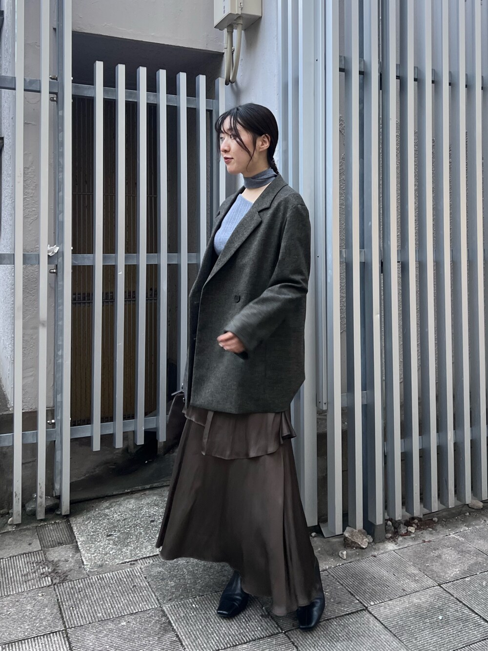 ブラック系のブーツ、ブルー系のニット/セーター、ブラウン系のテーラードジャケットを着用したレディースの秋コーディネートの2枚目の写真