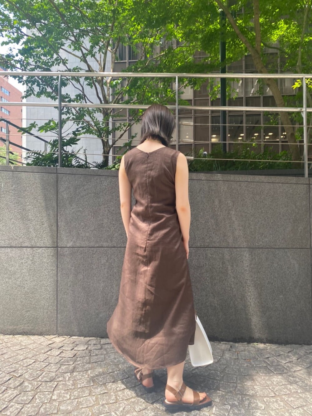 ホワイト系のハンドバッグ、ブラウン系のサンダル、ブラウン系のワンピースを着用したレディースの夏コーディネートの9枚目の写真