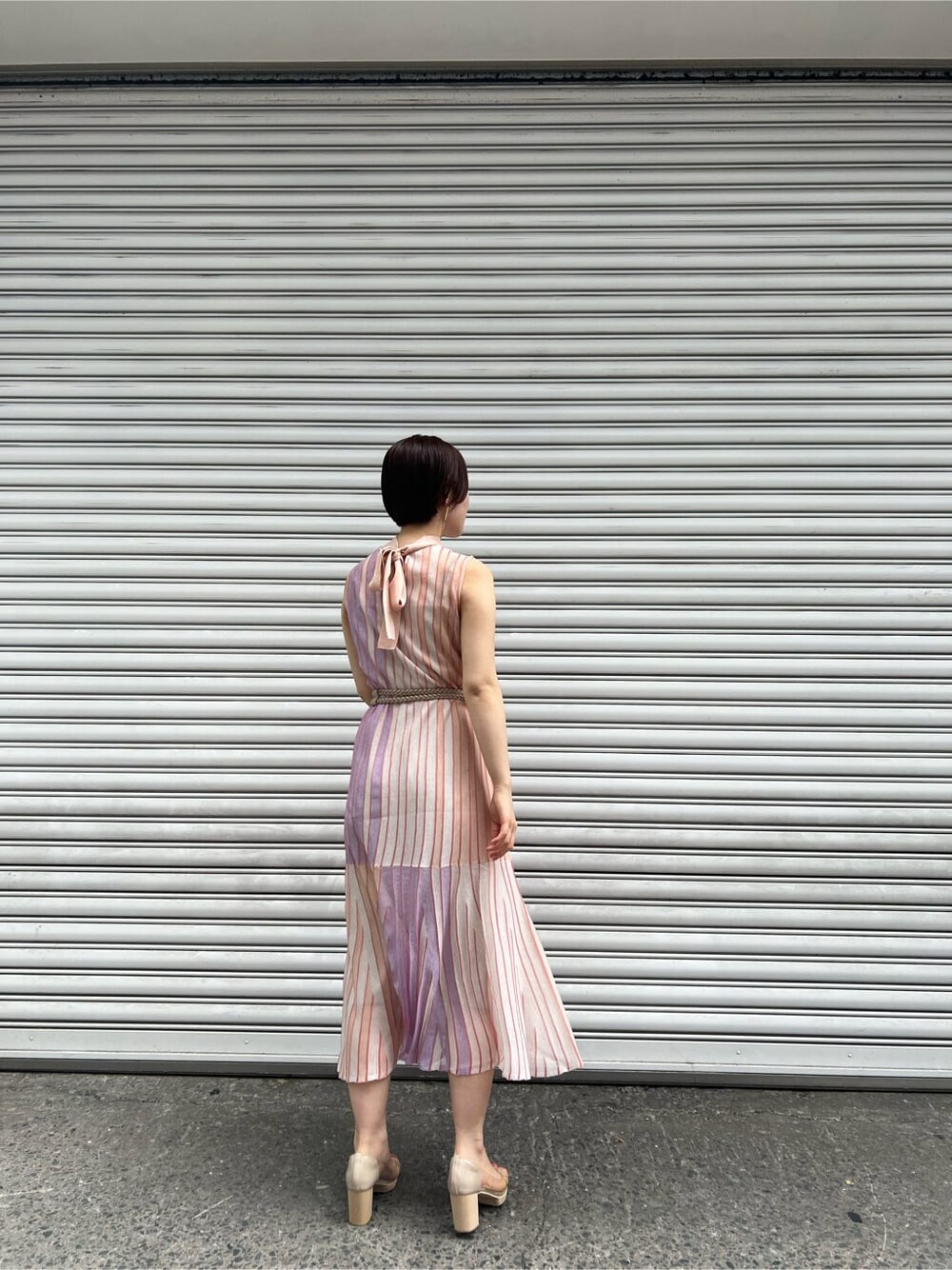 オレンジ系のワンピース、その他のパンプス、ホワイト系のカーディガン/ボレロを着用したレディースの春コーディネートの4枚目の写真