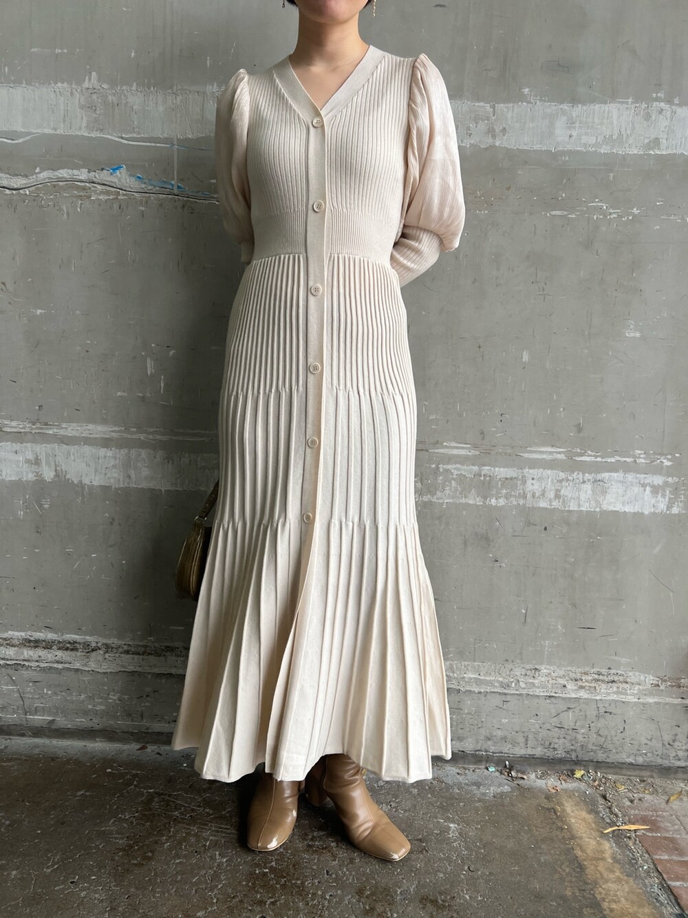 ベージュ系のブーツ、ホワイト系のワンピース、ベージュ系のハンドバッグを着用したレディースの冬コーディネートの7枚目の写真